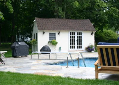 White Saltbox Pool Shed with a pool