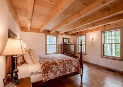 Bedroom with exposed wood beams and a wooden floor