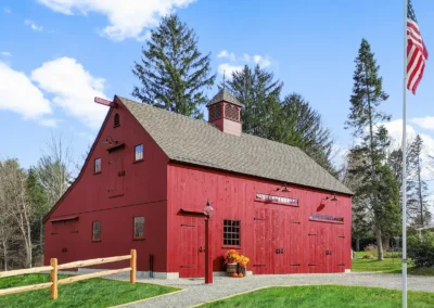 Red barn with two garage doors and a loft